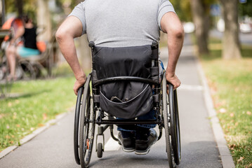 Handicapped man in wheelchair walk at the park alley