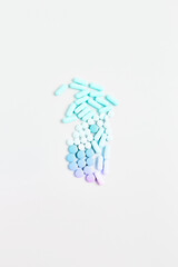 minimal concept. pills and capsules of pastel gradient color on a white background. vitamin skincare, creative layout, flat lay