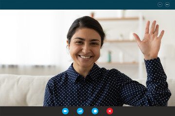Screen view portrait of smiling Indian young woman wave greet talking speaking on video call from...