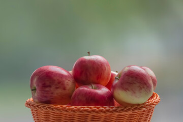 Apples in an orange basket on a defocused background