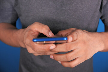 Fototapeta premium Close up of young man hand using smart phone.