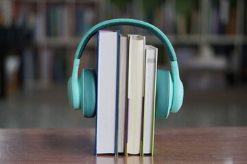 soft focus of the books stacked up with headphone on bookshelf background.