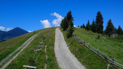 Lovely scenery of the mountain road. Wooden fence near the route.