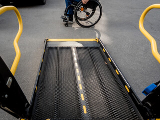 A man in a wheelchair moves to the lift of a specialized vehicle 