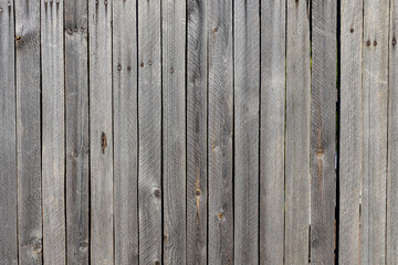 Beautiful horizontal texture of gray boards with knots and resin is in the photo