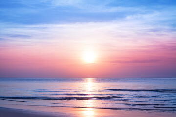 Beautiful morning sunrise, blue sea, pink sky, white clouds, yellow sun glow, golden reflection on...