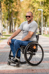 Handicapped man in wheelchair walk at the park alley