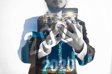 The hands of a man using a smartphone with modern technology are overlaid with an image of technology and innovation 2020. To move forward to 2021 with the most advanced information system interface.