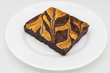 Big Chocolate Brownie with a Cheesecake Swirl on a White Plate