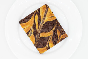Big Chocolate Brownie with a Cheesecake Swirl on a White Plate