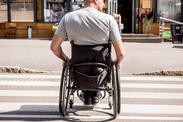 Handicapped man in wheelchair crossing street road