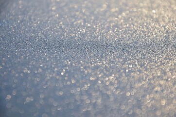 Rime on a car roof, closeup of sparkling defrosting ice
