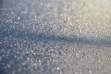 Rime on a car roof, closeup of sparkling defrosting ice