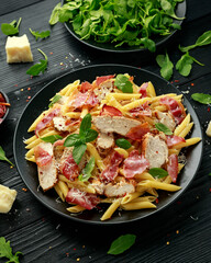 Chicken, bacon Penne pasta with parmesan cheese and basil. healthy food.