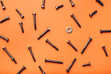 Bolts and nuts closeup on orange background.