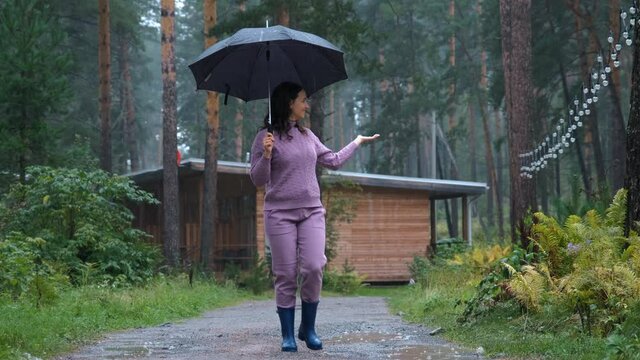 Young Smiling Woman with Umbrella Enjoying Walking in the Rain in Nature. Autumn Season, Harmony with Nature and People concept