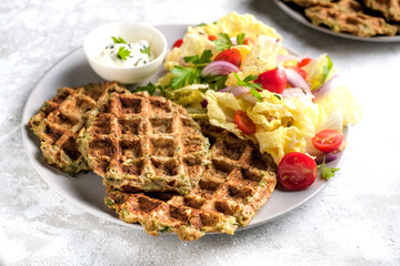 Vegetarian food of vegetable waffles with green salad, tomatoes on a plate