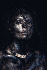 Fashion glamour portrait of a beautiful young caucasian woman. Bright messy black creative makeup. Dramatic dark image. The effect of a dirty face. Metal collar on the neck.