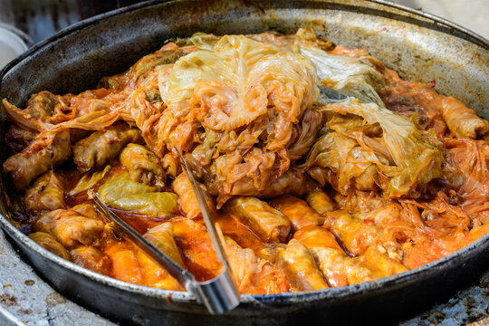 Freshly cooked large portion of cabbage rolls with meat and cabbage, a traditional Romanian food called sarmale cooked at a food market.