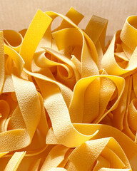 Uncooked pappardelle pasta close-up  -  Italian  food ingredient