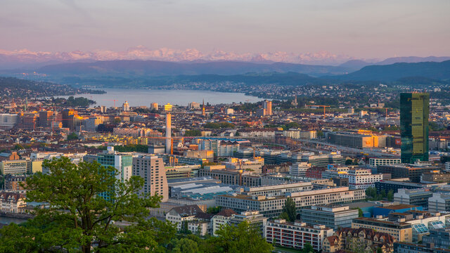 Panoramablick &uuml;ber Z&uuml;rich mit Z&uuml;richsee und Alpen im Hintergrund bei Abendlicht