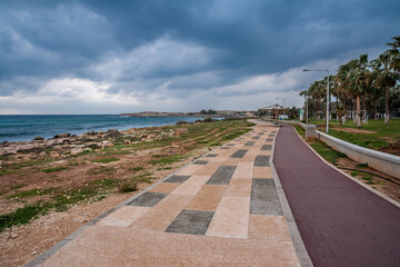 Embankment with lighting lanterns against the background of the rocky seashore.