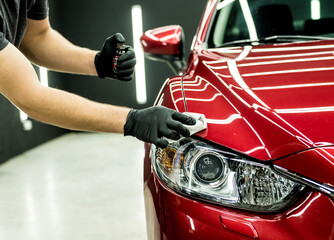 Car service worker applying nano coating on a car detail.