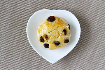 homemade scones are in a white heart-shaped plate.