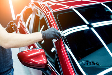 Car service worker applying nano coating on a car detail.