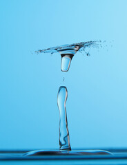 Naklejka na ściany i meble Water drop falling down. Abstract blue background.