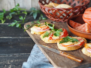 Breakfast with hot sandwiches with cheese and tomatoes and a cup of coffee on a wooden ancient background with ingredients for their preparation. Healthy natural food.