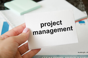 Project management team update schedule or scheduling on computer, business. the word Project management is written on a notebook