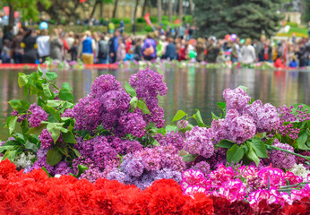 red carnations and lilacs on a marble military memorial