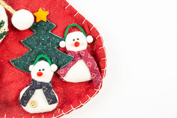 Christmas time - detail of two snowmen and a small tree on a red surface used for decoration and a blank space for your text