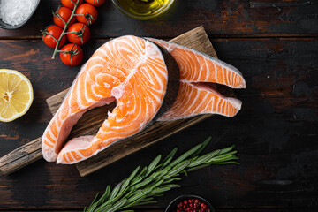 Trout steak raw fish with herbs, on old wooden table, top view