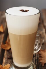 Coffee latte with beans and oak leaves on the table