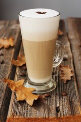 Coffee latte with beans and oak leaves on the table