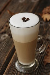 Coffee latte with beans and oak leaves on the table