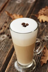 Coffee latte with beans and oak leaves on the table