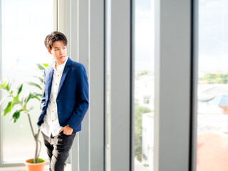 Smart LGBT business person wearing casual suits looking side way out of window from office.