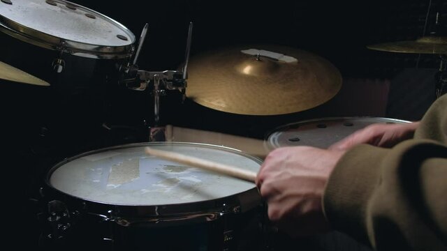 the drummer plays with sticks on a snare drum, home lesson paradiddle training