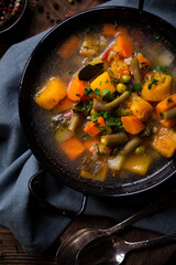 Vegetable soup with parsley on dark background