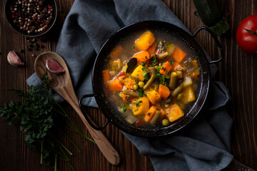 Vegetable soup with parsley on dark background