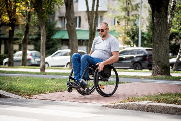 Handicapped man in wheelchair crossing street road