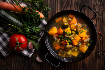 Vegetable soup with parsley on dark background