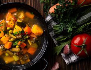 Vegetable soup with parsley on dark background