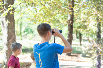 Children on a hike and look through binoculars, children's journ