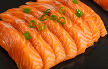 Slices of Raw Salmon Fillet on Black Background