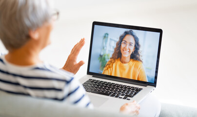 Senior woman is using laptop for conversation with daughter