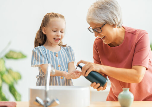 girl and her grandmother are washing hands